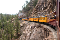 Nine cars being pulled by the old coal-driven steam engine